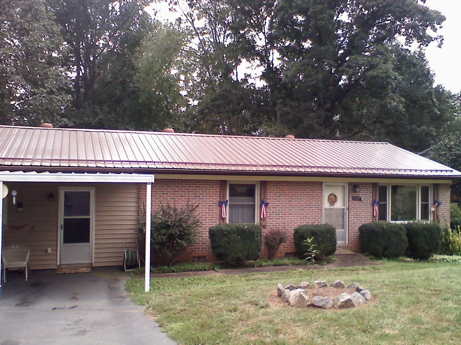 Bronze metal roof and carport on a brick ranch home — Roof Repair work by our crew in Howard